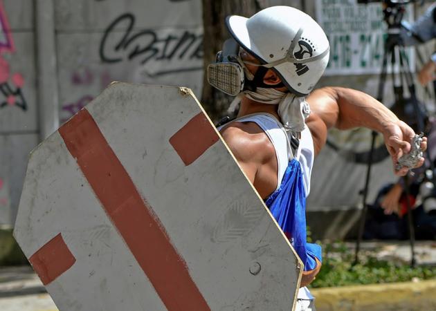 Un manifestant lance un projectile contre les forces de police, le 28 juillet 2017 à Caracas [JUAN BARRETO / AFP]