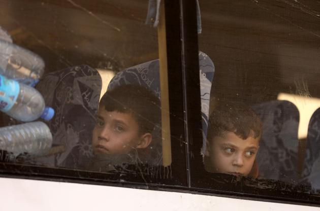 Photos d'enfants syriens syriens évacués de la Ghouta orientale, à leur arrivée à Qalaat al-Madiq, dans le nord de la Syrie, le 26 mars 2018 [OMAR HAJ KADOUR / AFP]